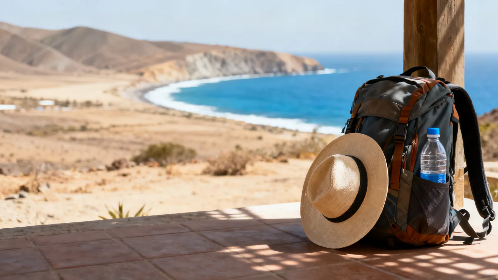 Photographic illustration of a day pack on a terrace overlooking a dry coastal bay