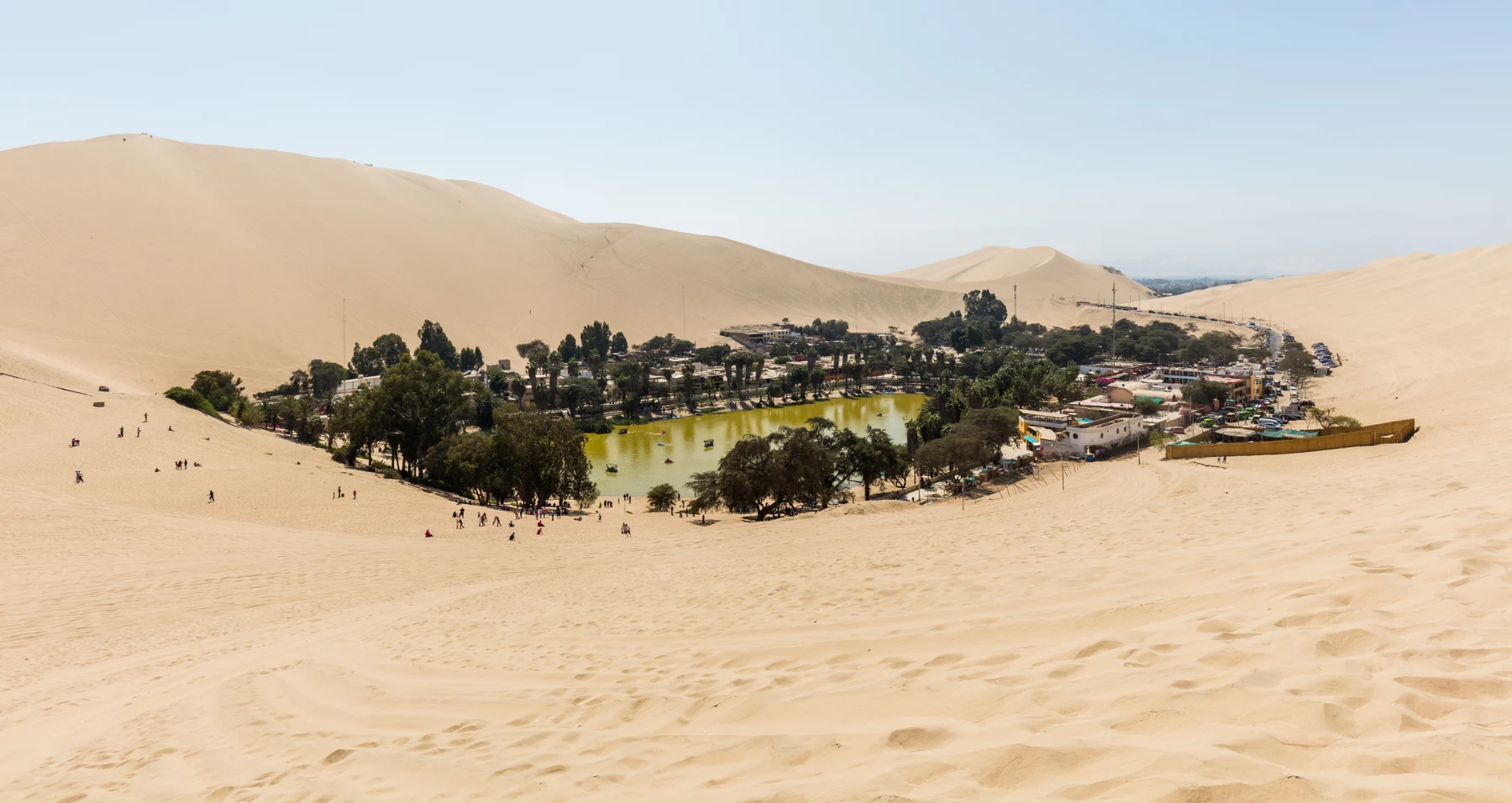 Huacachina lagoon and settlement among pale sand dunes