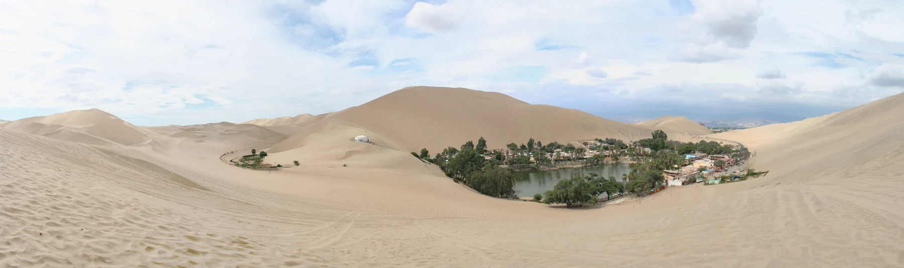 The Huacachina settlement enclosed by broad desert dunes